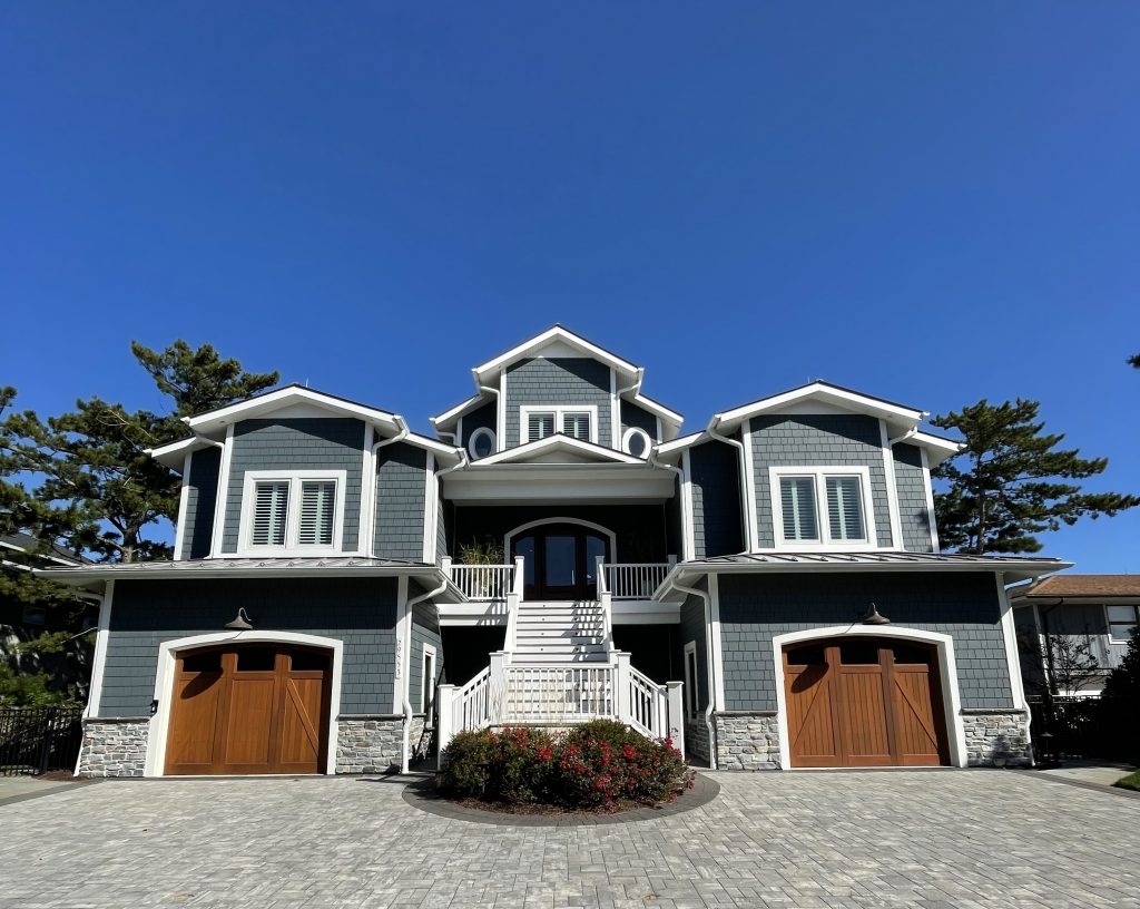 Blue-gray custom home with arched carriage-style garage doors