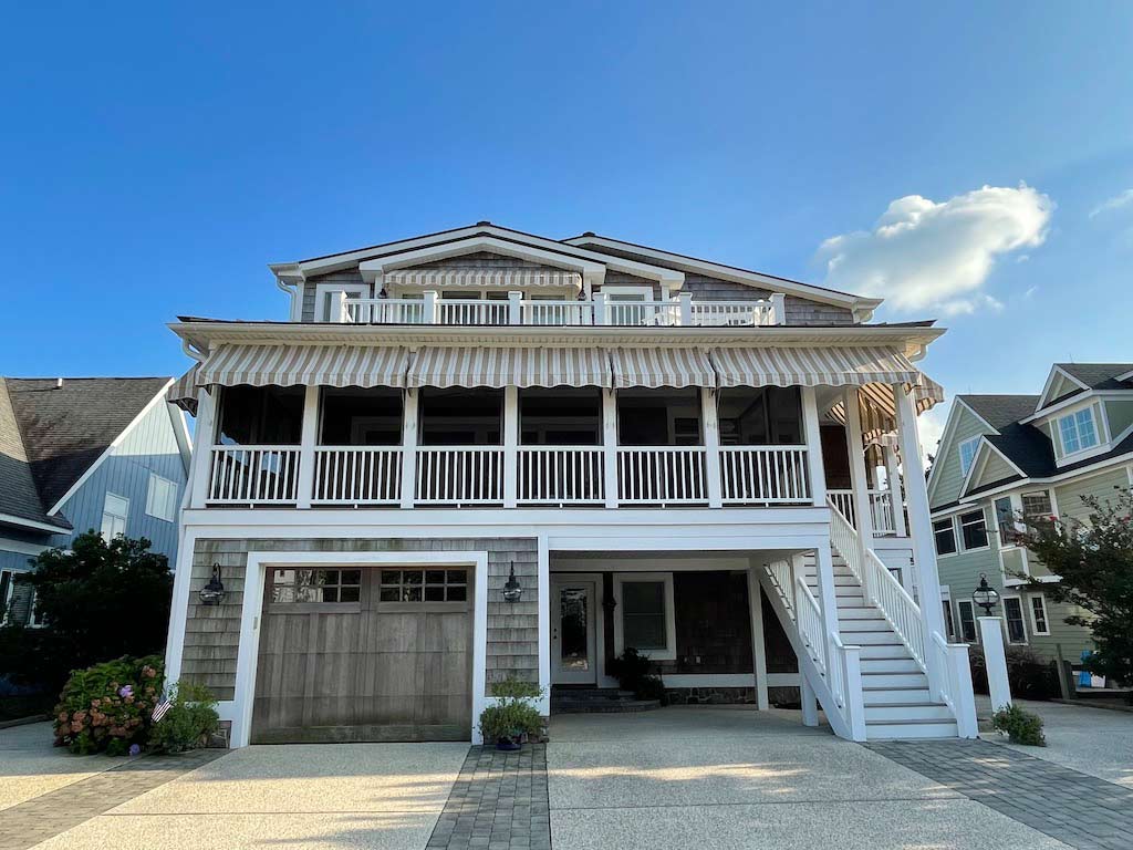 Custom beach house with a spacious deck and white railings, showcasing outdoor living potential in Bethany Beach, Delaware.